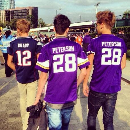 My two friends and I walked towards Wembley Stadium to watch Minnesota Vikings vs Pittsburgh Steelers. Two are wearing Adrian Peterson jerseys and one wearing a Tom Brady. The photo is taken from behind us, with a stream of fans in front.